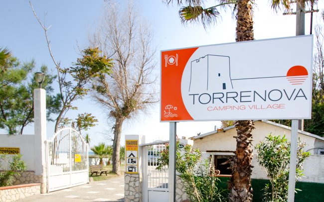 Insegna di un campeggio con torre stilizzata.