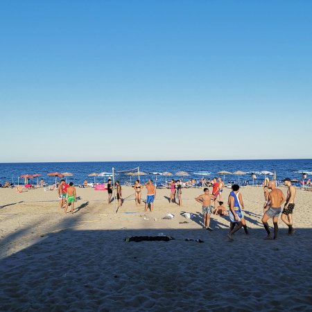 Persone giocano a calcio su una spiaggia.