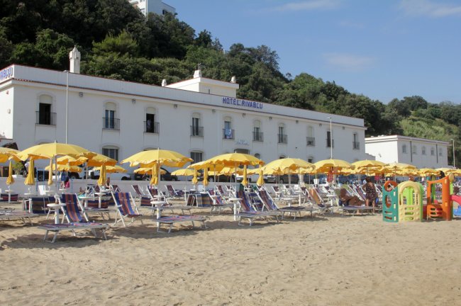 Spiaggia con lettini e ombrelloni gialli.