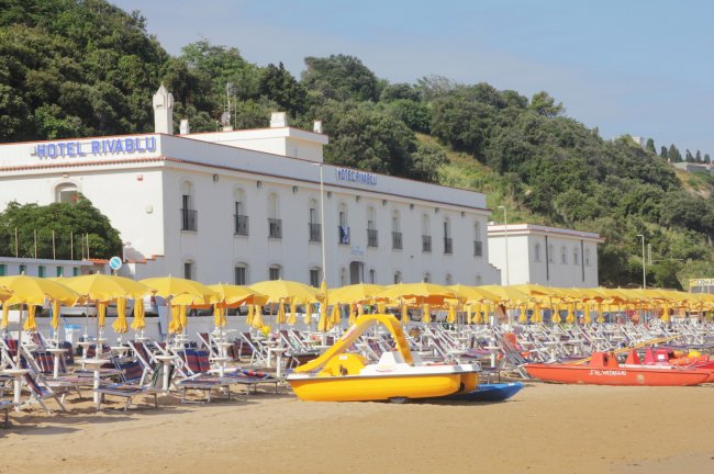Spiaggia con pedalò, lettini, ombrelloni.