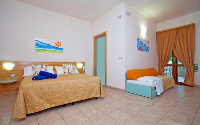 Camera d'albergo con letto matrimoniale e divano letto.