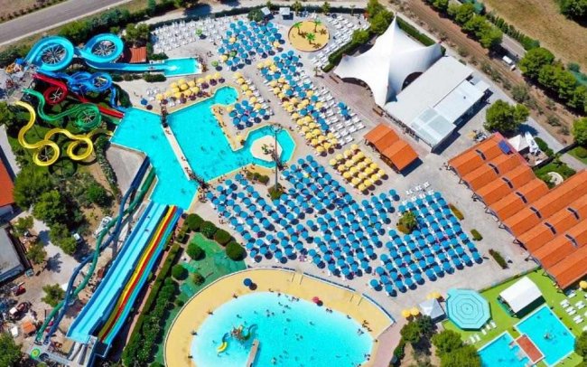 Veduta aerea di un parco acquatico con scivoli e piscine azzurre.