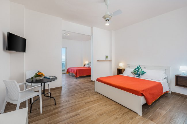 Due letti con copriletti arancioni in una camera moderna.